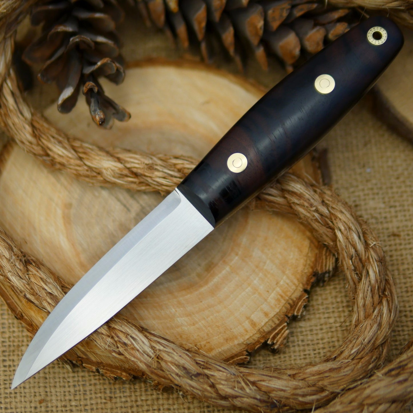 An Adventure Sworn Woodsman bushcraft knife with katalox handle scales.