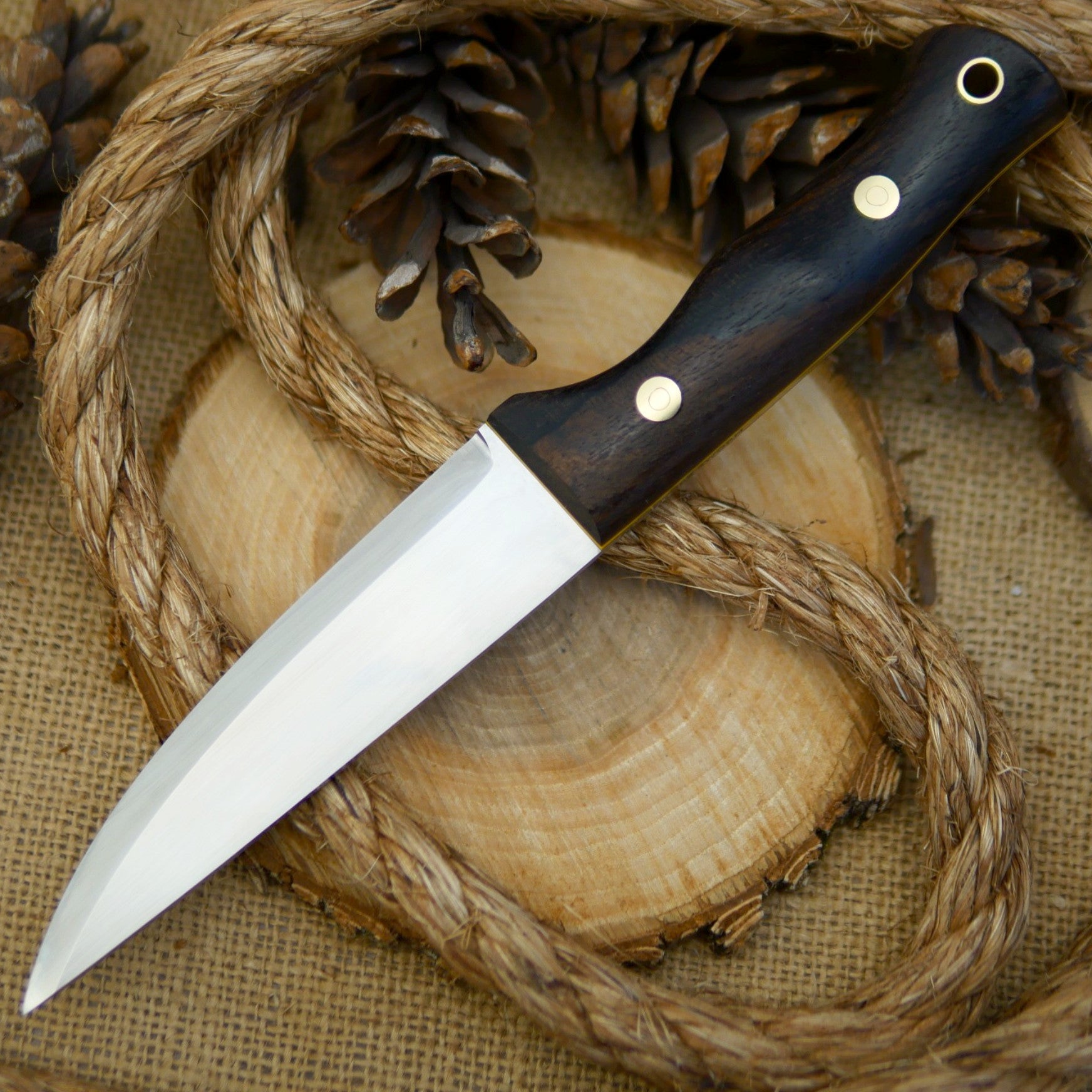 An Adventure Sworn Tradesman bushcraft knife with ziricote handle scales.