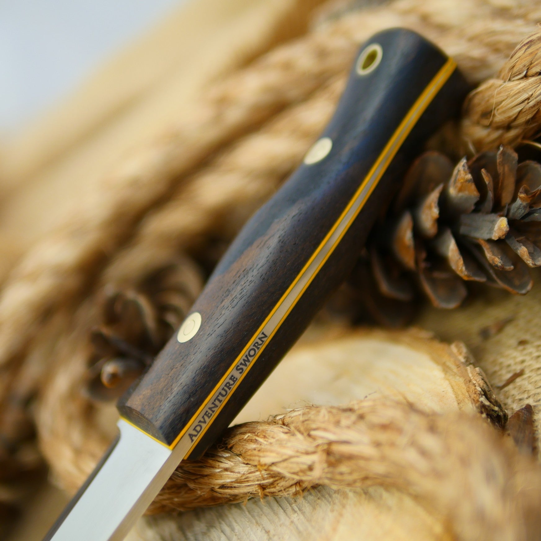 An Adventure Sworn Tradesman bushcraft knife with ziricote handle scales.