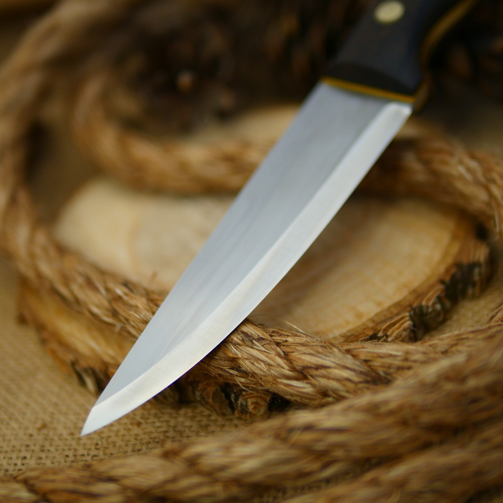 An Adventure Sworn Tradesman bushcraft knife with ziricote handle scales.