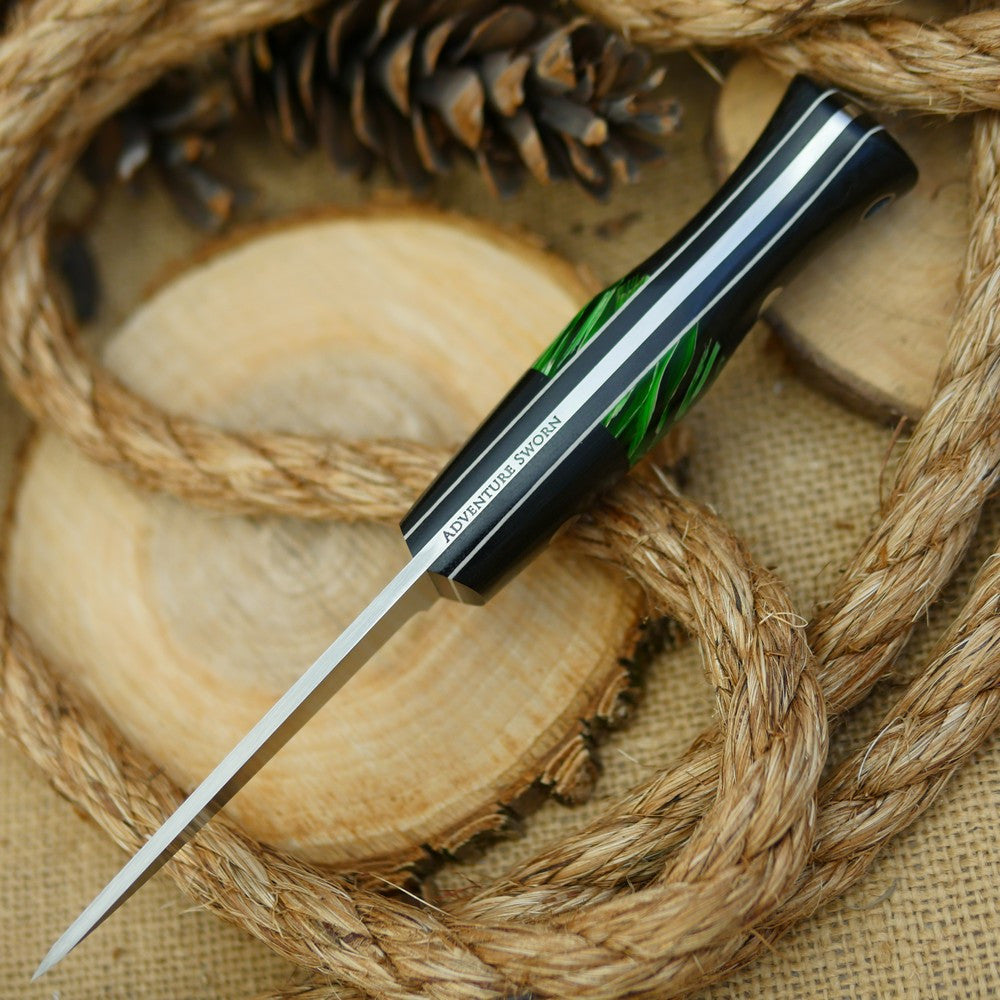 An Adventure Sworn bushcraft knife with black canvas micarta handle scales and green raffir stripes spacer.