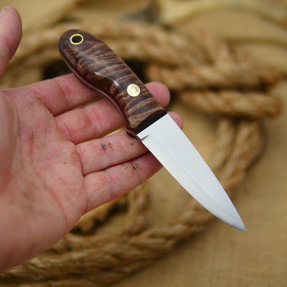 An Adventure Sworn Walker Bushcraft Knife with dark brown curly maple handle scales and thick maroon liners.