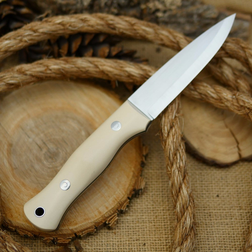 An Adventure Sworn Mountaineer bushcraft knife with ivory paper micarta handle scales and forest green g10 liners.