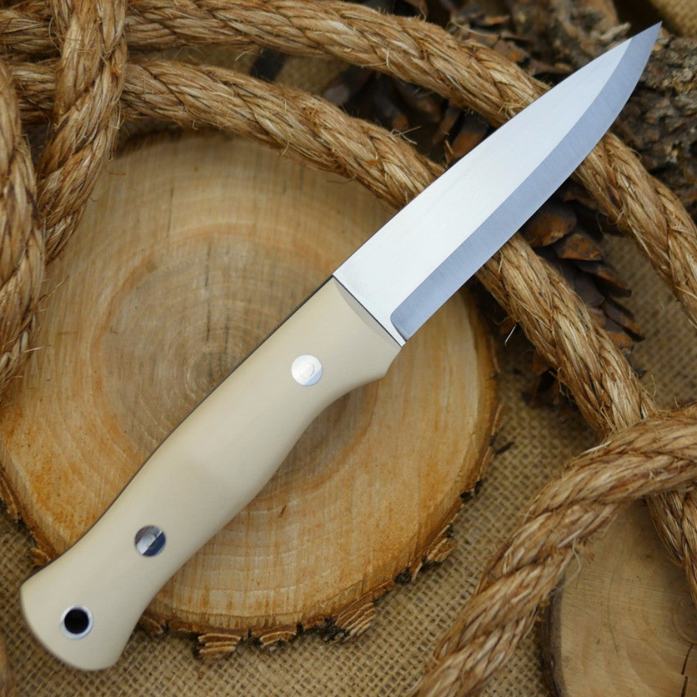 An Adventure Sworn Mountaineer bushcraft knife with ivory paper micarta handle scales and forest green g10 liners.