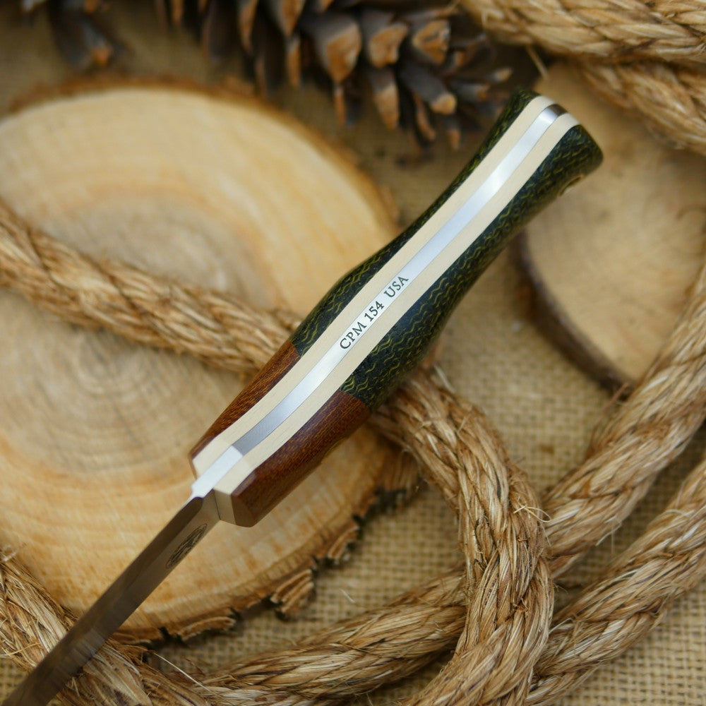 An Adventure Sworn bushcraft knife with evergreen burlap handle scales and natural brown canvas micarta bolster.
