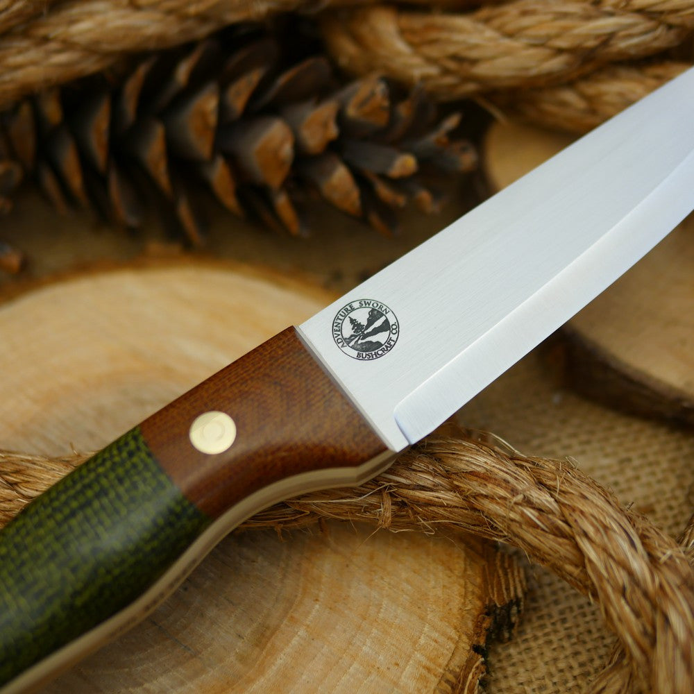 An Adventure Sworn bushcraft knife with evergreen burlap handle scales and natural brown canvas micarta bolster.