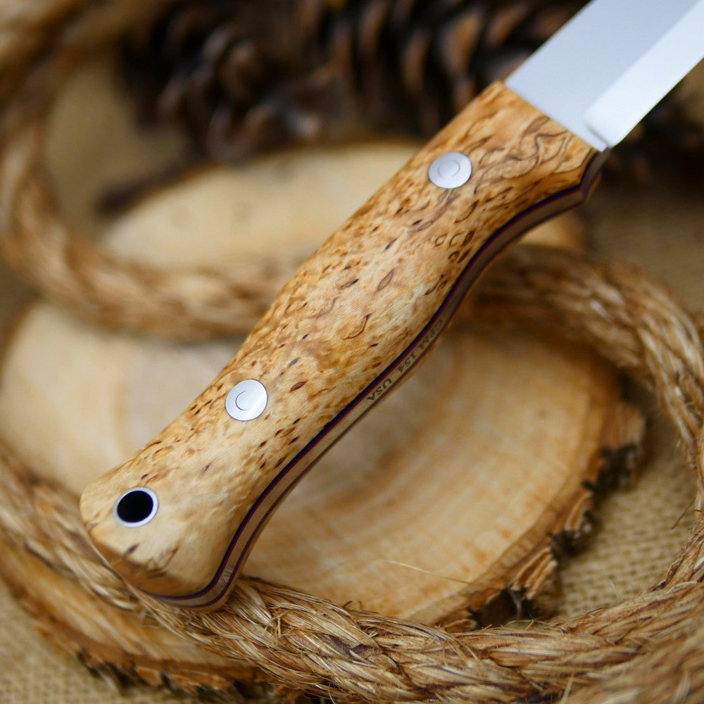 An Adventure Sworn Mountaineer bushcraft knife with karelian birch handle scales and thin blue and red liners.