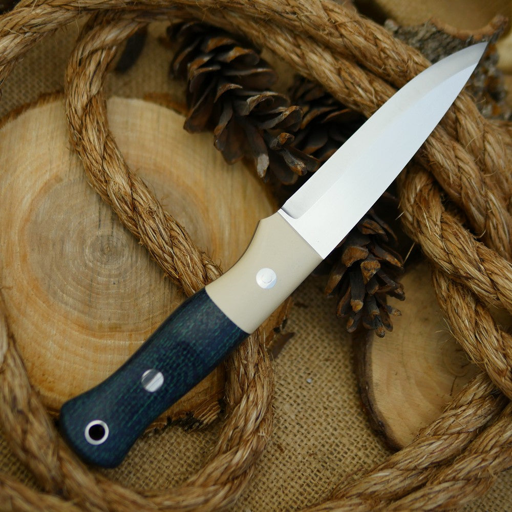 An Adventure Sworn Mountaineer bushcraft knife with navy blue burlap and ivory paper.